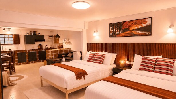 A hotel room with two beds, a dining area, a kitchen, and a painting on the wall. - PhayaThai Autumn Hideaway • 2 Queen Beds • Vintage Kitchen (Krung Thep Maha Nakhon)