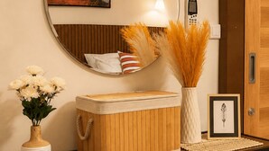 A wooden dresser with a mirror, a vase with flowers, a framed picture, and a lamp. - PhayaThai Autumn Hideaway • 2 Queen Beds • Vintage Kitchen (Krung Thep Maha Nakhon)