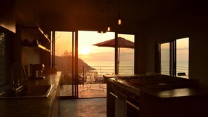 Una cocina moderna con vista al atardecer sobre el océano.