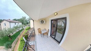 A balcony with a table and chairs, a view of the neighborhood, and a door leading outside. - Cozy Apartment With Pool Near Umag (Umag)