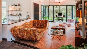 Un soggiorno moderno con un divano a stampa leopardo, un tavolino in vetro e un'area pranzo con televisore e posti a sedere all'aperto.