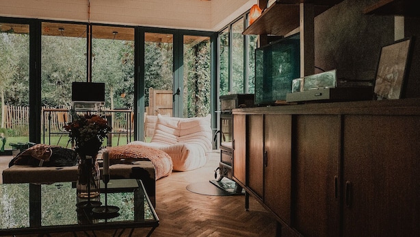 Una cucina moderna con zona pranzo, ampie finestre e vista sul verde.
