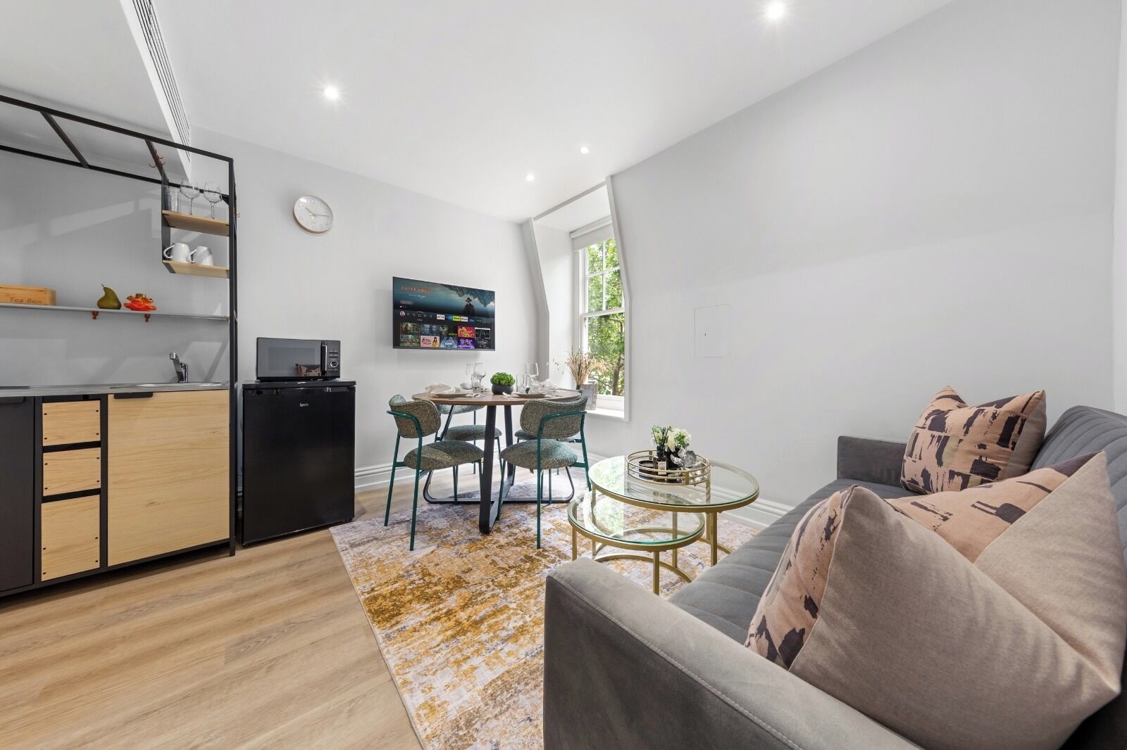 A modern living space with a kitchen, dining area, and seating area.