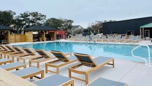 Uma área à beira da piscina com espreguiçadeiras e piscina.