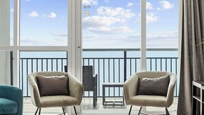 A balcony with two chairs, a small table, and a view of the sea. - 2-Bedroom Oceanfront Condo, Bay View Resort , 6th Floor, Indoor & Outdoor Pools (Myrtle Beach)