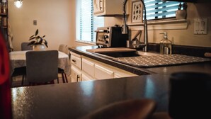 Une cuisine équipée d’un plan de travail, d’un évier et de placards.