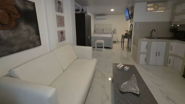 En moderne stue med sofa, sofabord og fjernsyn.