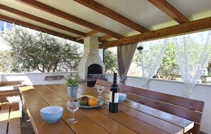 A wooden table with a bowl, wine glasses, and a bottle of wine. - Apartment With Garden and BBQ Area (Umag)