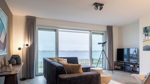 A modern living room with a sofa, a coffee table, a TV, and a telescope. - Lumen Mare by Interhome (Sint-Annaland)