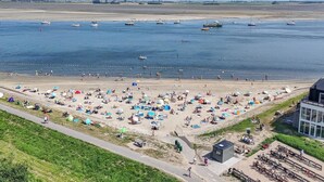 A beach with boats, umbrellas, and people. - Lumen Mare by Interhome (Sint-Annaland)