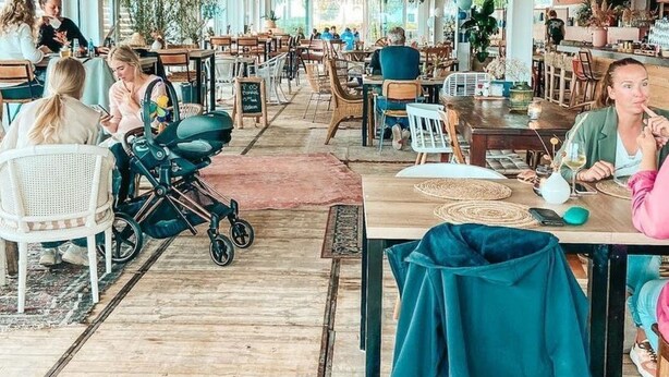 Ein geräumiges Restaurant mit hohen Decken, hängenden Korblampen und vielfältigen Sitzmöglichkeiten.