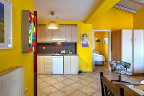 Uma cozinha com armários, lava-louças e luminária pendente.
