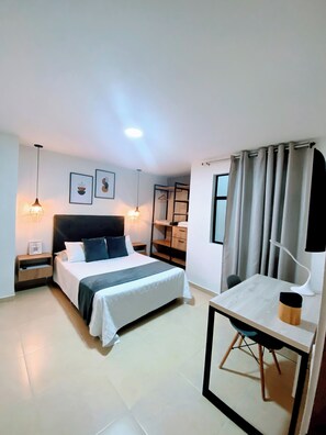 A bedroom with a bed, bedside tables, a desk, and a chair. - Adorable 1-bedroom apartment in a charming setting, perfect for relaxing (Sabaneta)