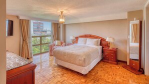 A spacious bedroom with a large bed, a wooden nightstand, a mirror, and a view of the outside. - Stylish Stay in Condesa for Football Fans (Mexico City)