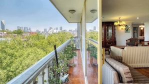 A balcony with a city view, a sofa, and a chandelier. - Stylish Stay in Condesa for Football Fans (Mexico City)