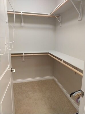 Ein Zimmer mit beigem Teppich, weißen Wänden und einer weißen Tür.