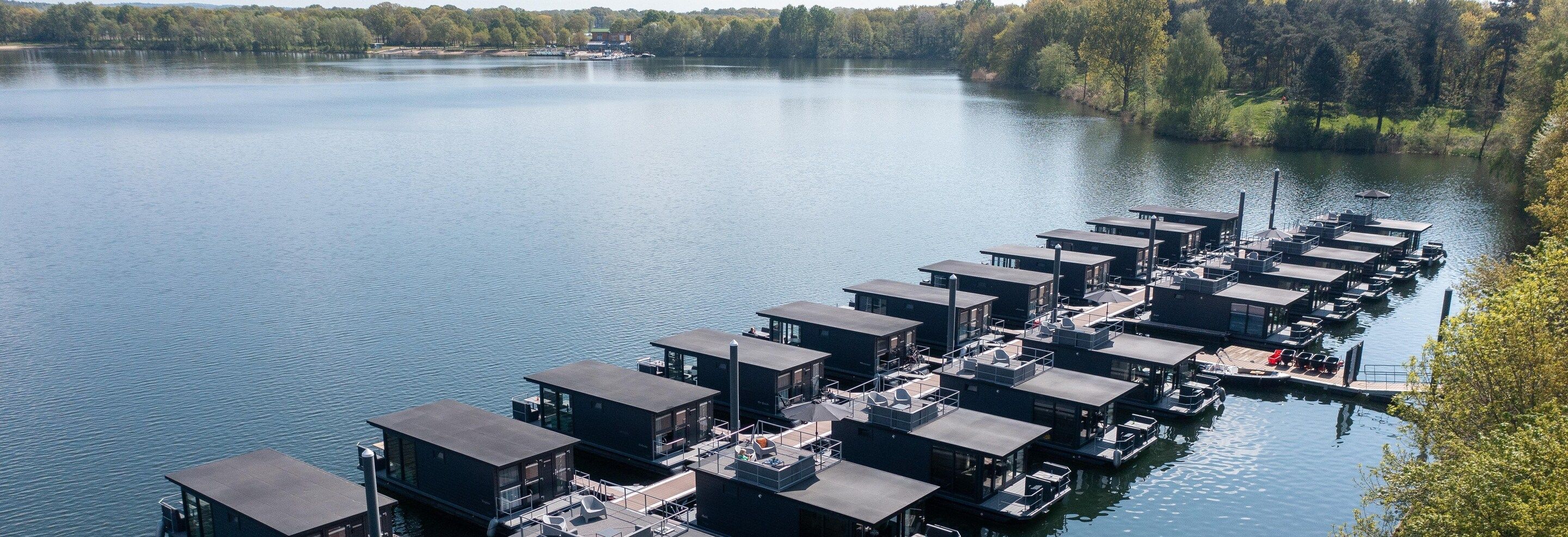 A series of floating structures with multiple levels, connected by walkways, over a calm body of water.