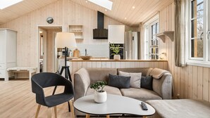 A modern interior with a wooden ceiling, a sofa, a coffee table, and a dining area. - "Martta" - 250m from the sea by Interhome (Knebel)