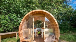 A wooden geodesic dome structure with a glass door, a small wooden table, and a bench outside. - "Martta" - 250m from the sea by Interhome (Knebel)