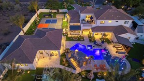 Ein Wohnhaus mit Swimmingpool, Sitzgelegenheiten im Freien und einem Tennisplatz.