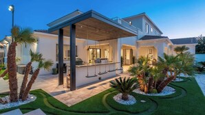 Ein modernes Haus mit überdachter Terrasse, Schwimmbad und gepflegtem Garten.