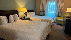 A hotel room with two beds, a nightstand with a lamp, a chair, and a dresser. - 110 - Next to Disney - Pool (Orange County)
