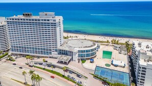 A high-rise hotel with a beach view, a tennis court, and a parking area. - 530 - Large Studio Ocean View (Miami Beach)