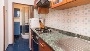 A compact kitchen with a stove, oven, and a microwave. - Cozy Holiday Studio in Umag (Umag)