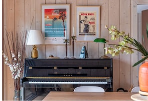 Ein Klavier mit Yamaha-Logo, ein Poster von Moon River und ein Poster von Escapades Musicales.