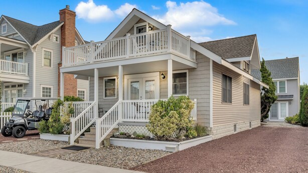Une maison à deux étages avec un balcon, un garage et une allée.