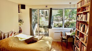 Une chambre avec un grand lit, un bureau et une bibliothèque.