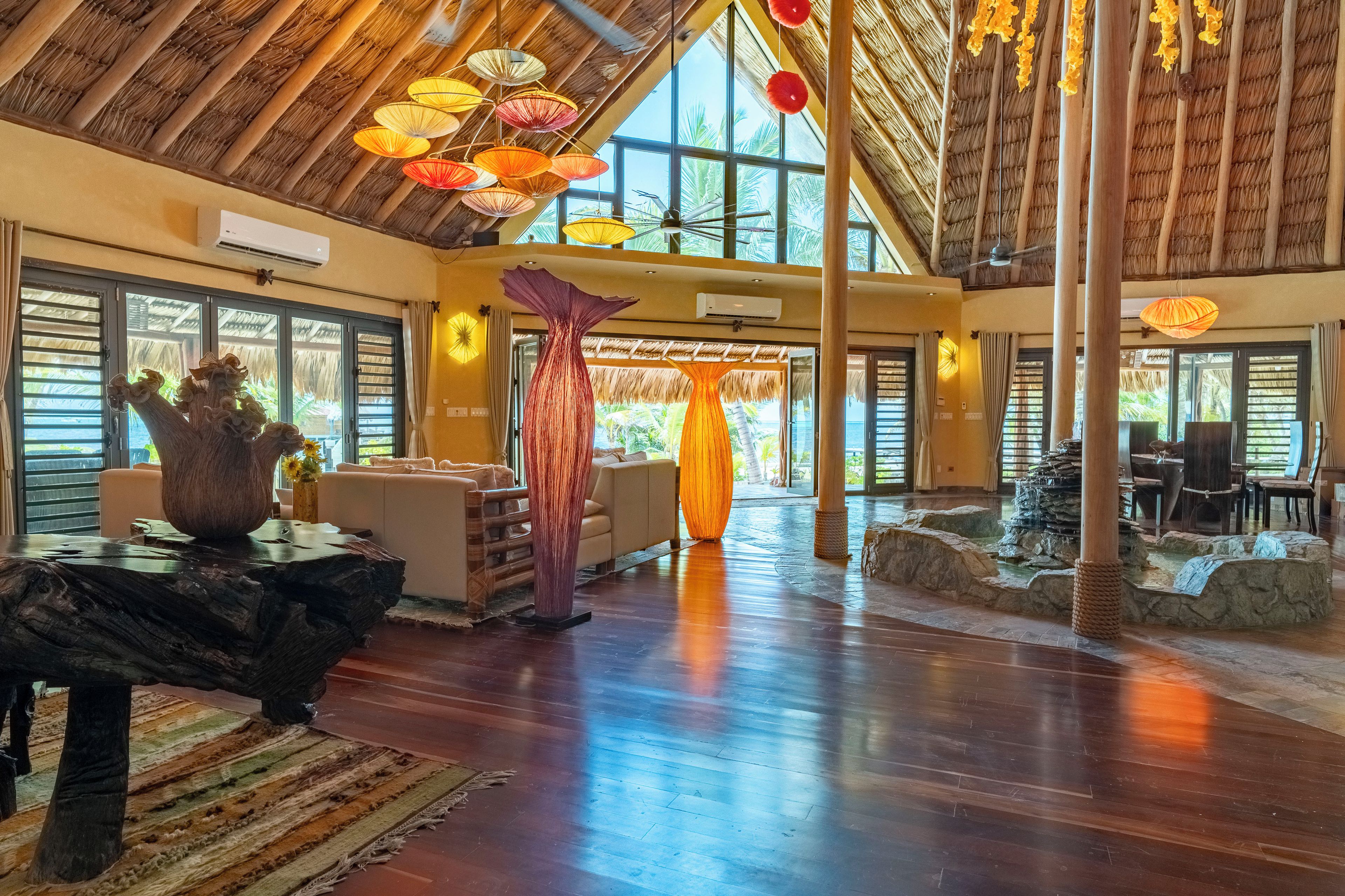 A spacious interior with a high ceiling, large windows, and a central water feature.
