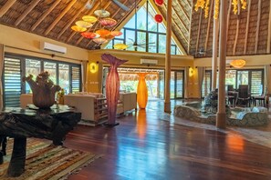 A spacious interior with a high ceiling, large windows, and a central water feature.
