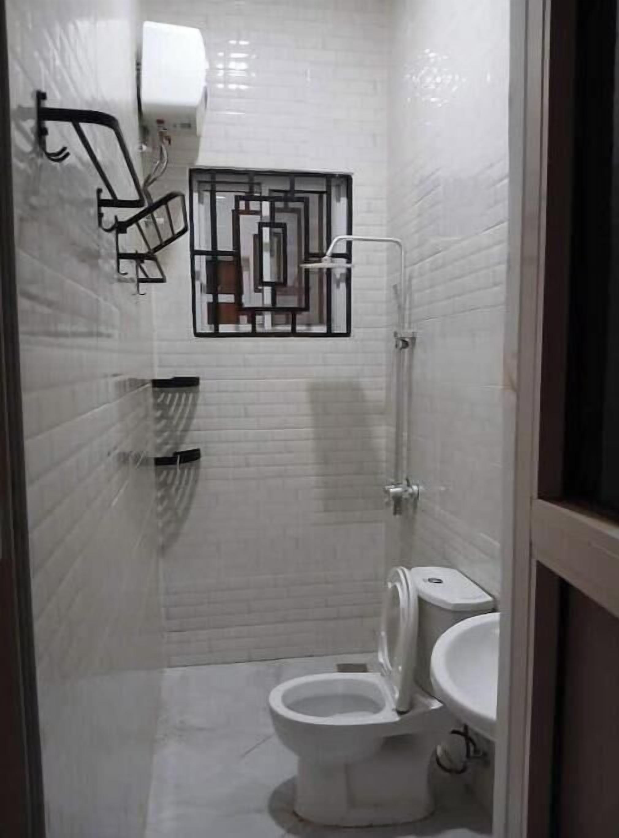 Une salle de bain équipée de toilettes, d’un bidet et d’un porte-serviettes.