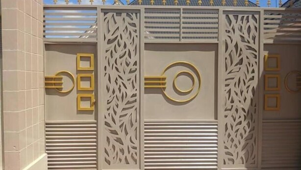 A gated entrance with decorative panels and a metal gate. - Peaceful Central Stay at Pristine Homes (Kilimanjaro Region)