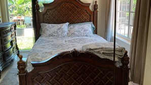 A bedroom with a wooden bed, a desk, a chair, a lamp, and a view of the outdoors. - Cozy Miramar 1 Bedroom with POOL for vacation, travel nurse short, longterm rent (Miramar)