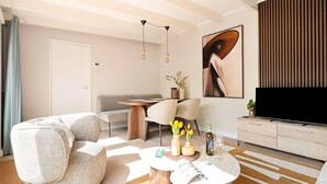 A modern living room with a sofa, coffee table, and TV stand. - Fantastic Holiday Home Near hot tub (Sint Maartensvlotbrug)