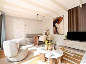 A modern living room with a sofa, coffee table, and TV stand. - Fantastic Holiday Home Near hot tub (Sint Maartensvlotbrug)