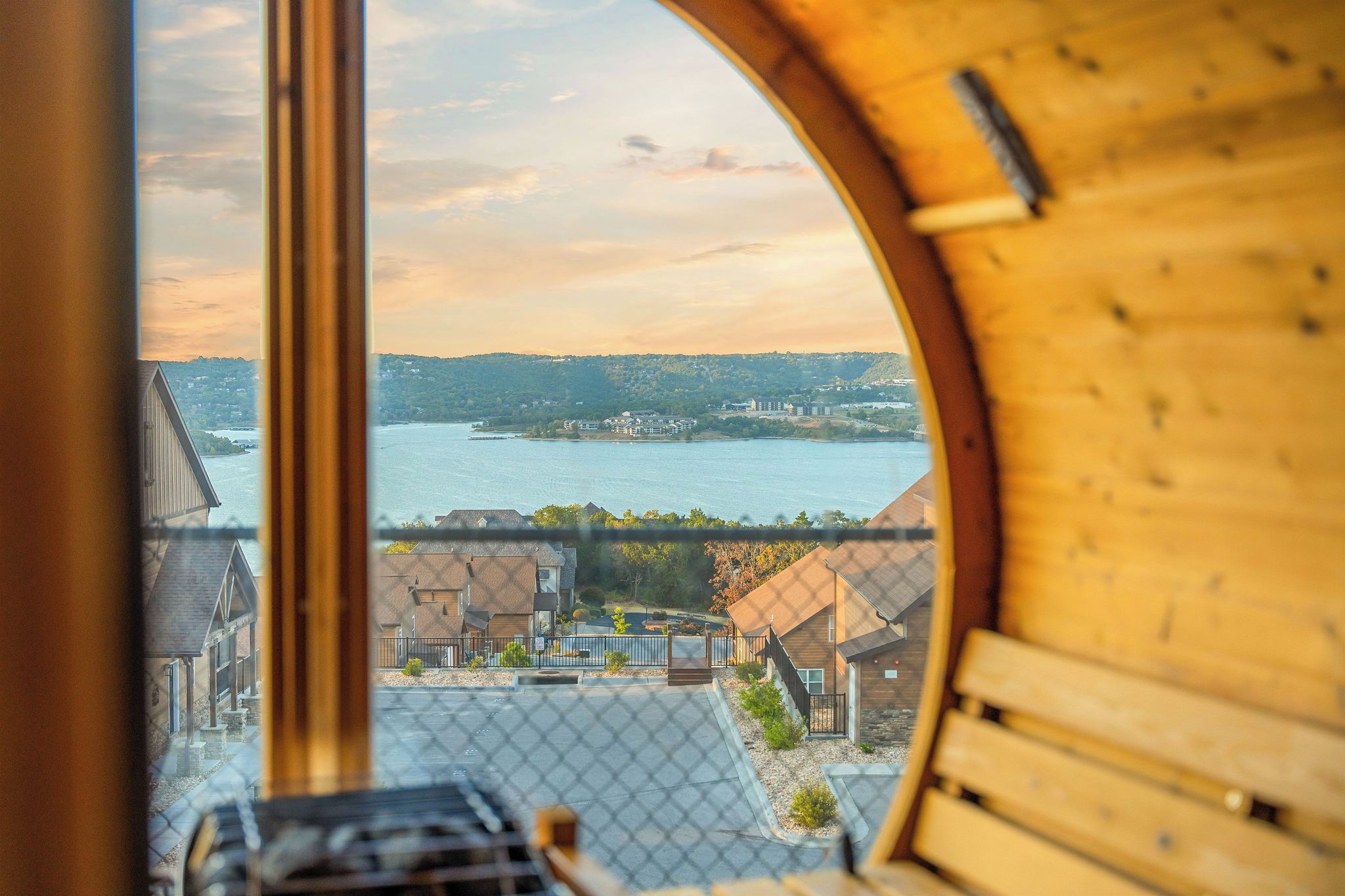 A view through a circular window of a building with a river and distant hills.