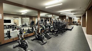 A gym with stationary bikes, mirrors, and exercise equipment.