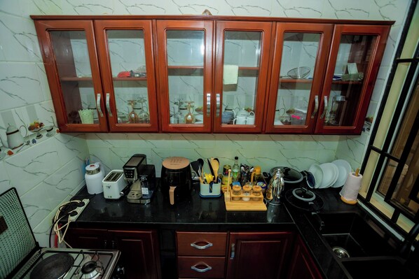 A kitchen with wooden cabinets, a gas stove, and various kitchen appliances.