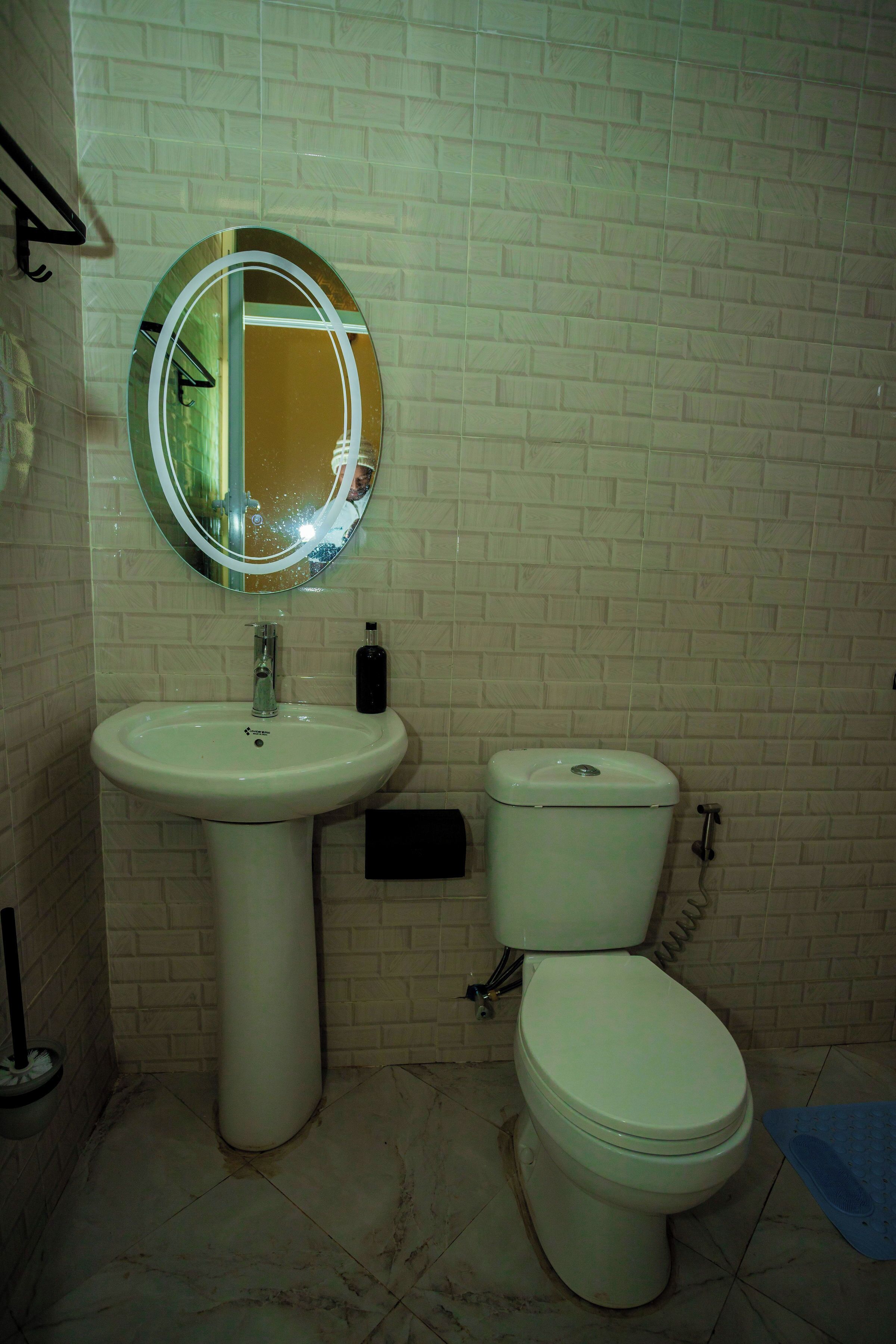 A bathroom with a sink, toilet, and a mirror.