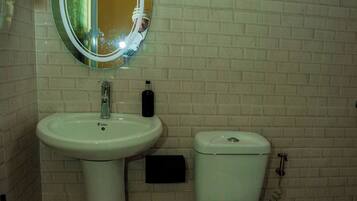 A bathroom with a sink, toilet, and a mirror.