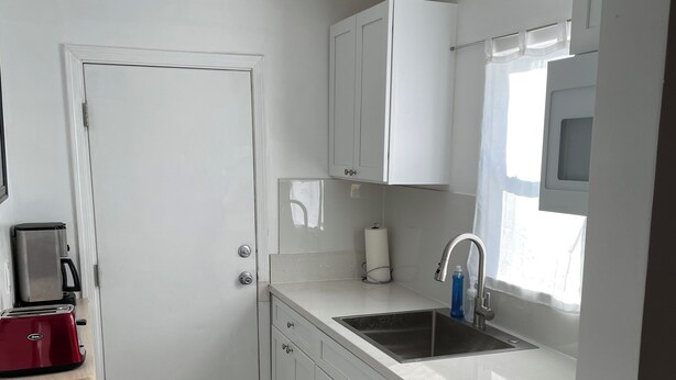 A modern kitchen with white cabinets, a stainless steel sink, and a red toaster. - Your own little house.#D Pet-Friendly (Phoenix)