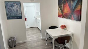 A modern kitchen with a white countertop, a trash can, a clock, and a painting on the wall. - Your own little house.#D Pet-Friendly (Phoenix)