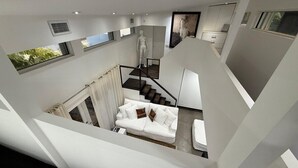 Een modern interieur met een witte trap, een witte bank met kussens, en een minimalistisch design.