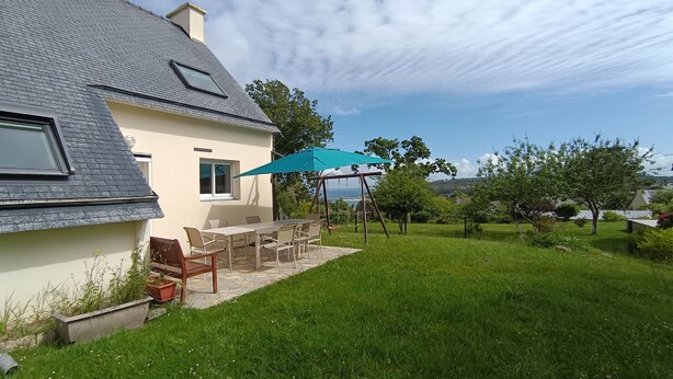 Une maison avec un patio, une balançoire et une vue sur le paysage.