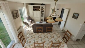 Un espace repas comprenant une table, des chaises, un canapé et un lustre.
