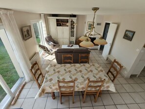 A dining area with a table, chairs, a sofa, and a chandelier. - Family villa with sea views - Morgat hills (Crozon)