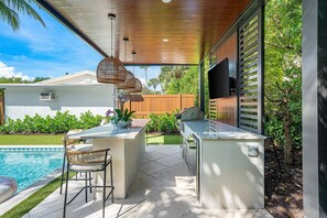 Dine outdoors in a beautifully shaded setting overlooking the pool. - Heated Pool Coastal Retreat Near Beach & Ave (Delray Beach)